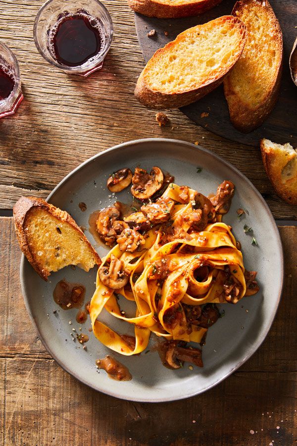 a plate of pasta and bread on a wooden table