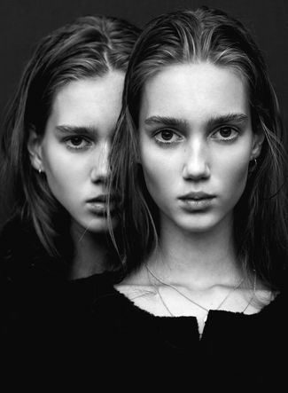 two young women with long hair and one is staring at the camera, while the other looks