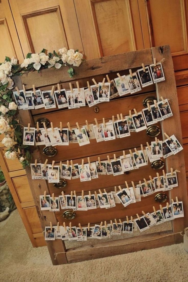 an old wooden board with pictures pinned to it and flowers on the wall next to it