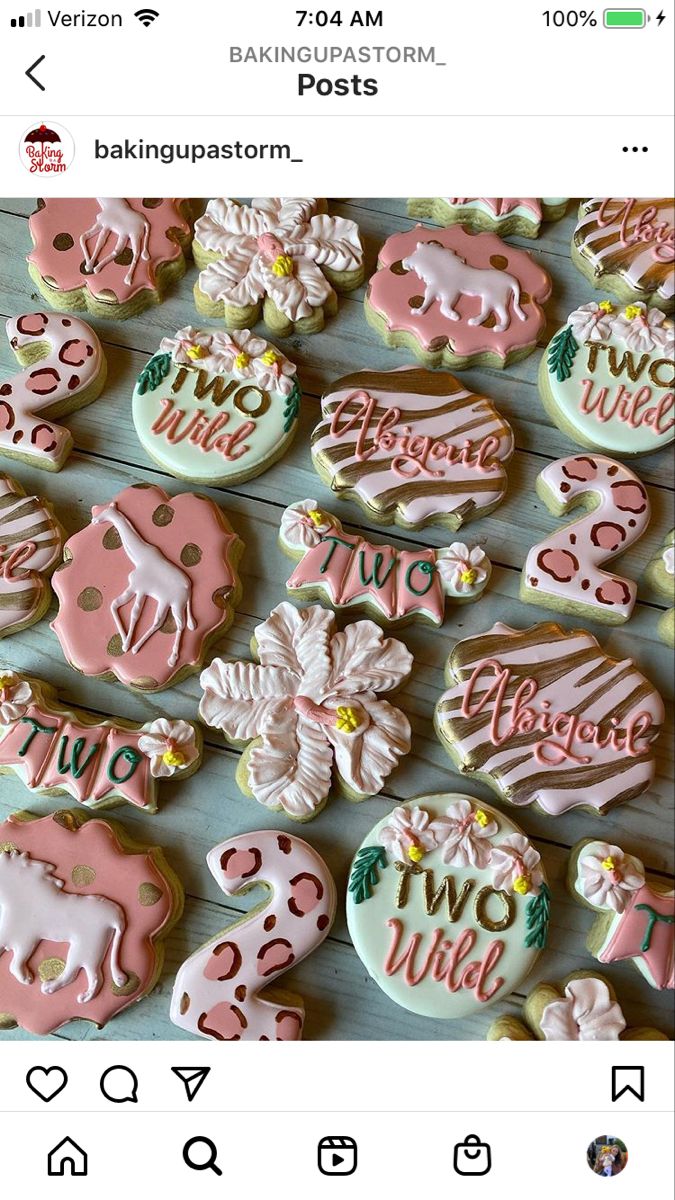 some decorated cookies on a table with pink and white frosted ones in the middle