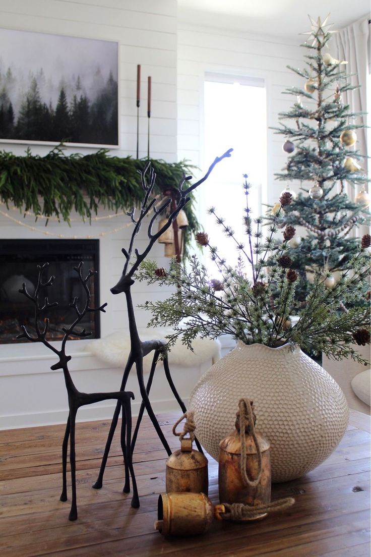 a living room with a christmas tree and decorations on the floor in front of a fireplace