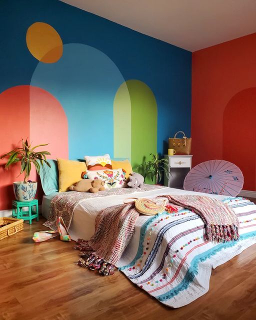 a bedroom with colorful walls and wooden floors