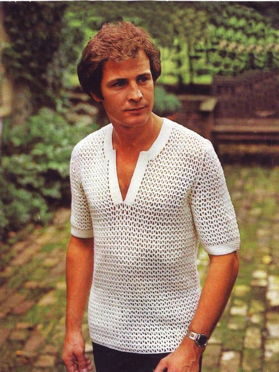 a man in white shirt holding a tennis racquet on brick walkway next to trees