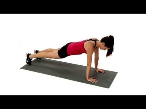 a woman is doing push ups on a mat