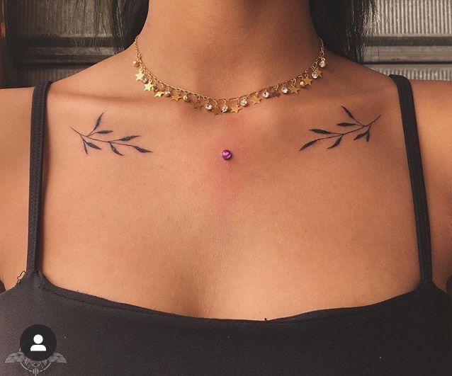 a woman's chest with two small tattoos on her left side and an arrow in the middle