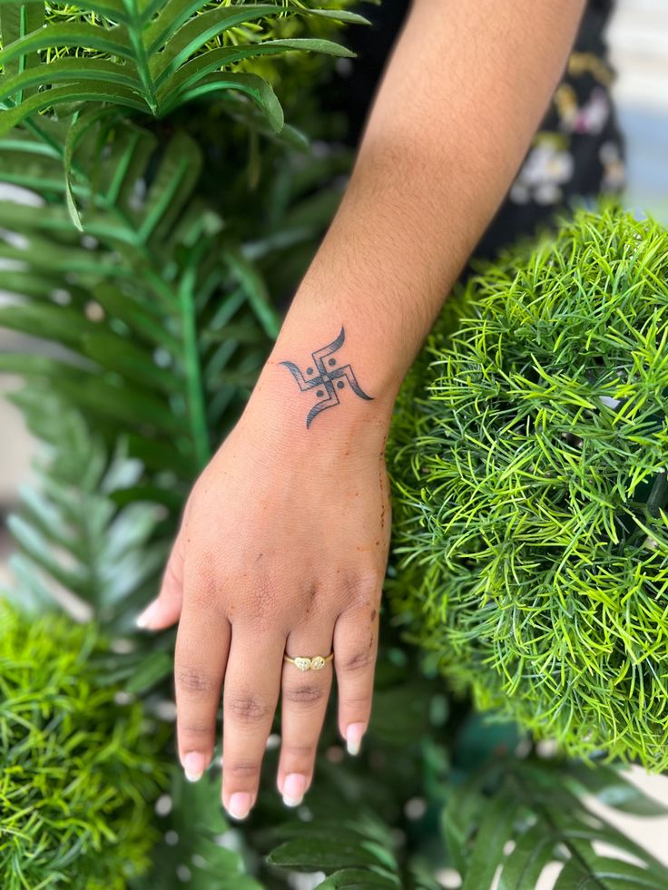 a woman's hand with a small tattoo on it