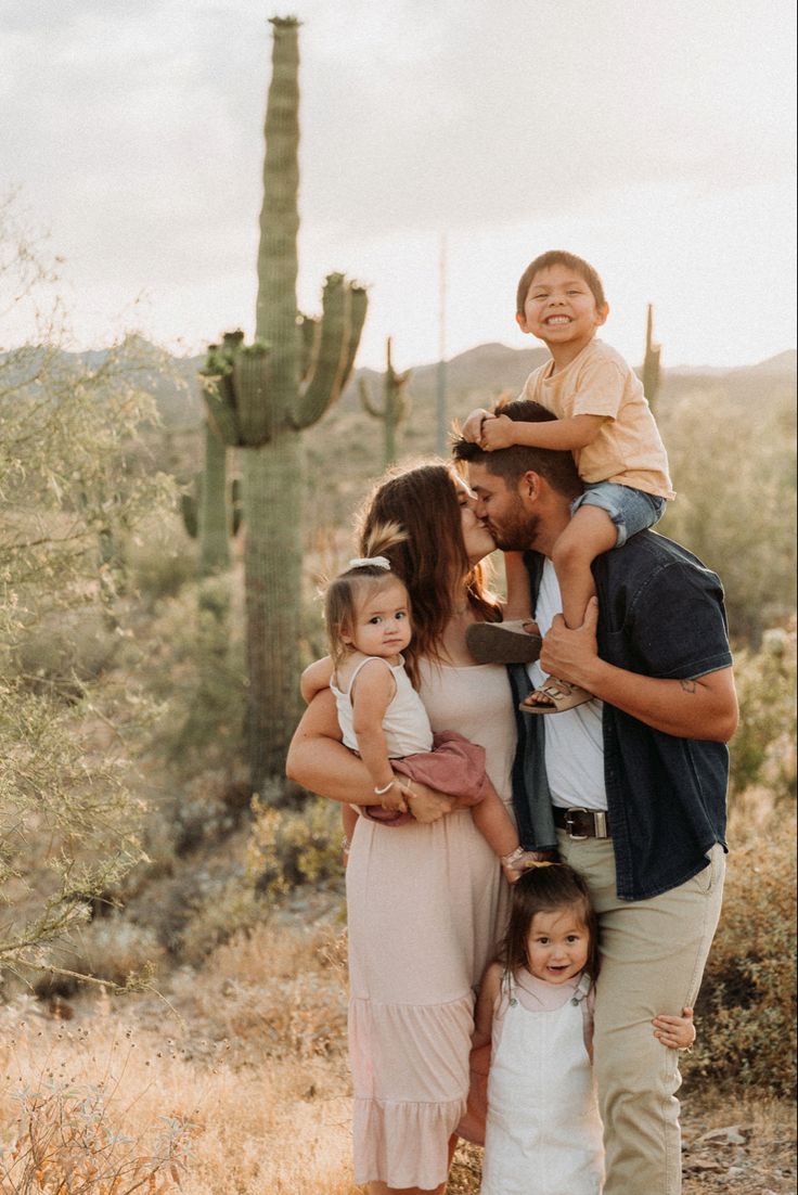 a family posing for a photo in front of a cactus