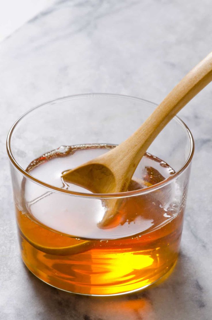 a wooden spoon in a glass filled with liquid