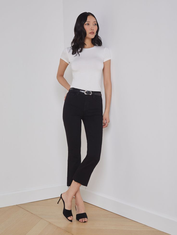 A high-rise cropped flare jean in a premium denim with a saturated black hue. Design hugs from waistband to knee before extending into a flared cropped leg finished with raw hem. Includes five-pocket construction and front zip fly closure with tonal button. | L'AGENCE Kendra Cropped Flare Jean In Black Cropped Flares Outfit, Cami Nyc, Cropped Flare Jeans, Cropped Flares, Bottom Clothes, Premium Denim, Swimwear Accessories, Blazer Coat, Cropped Jeans