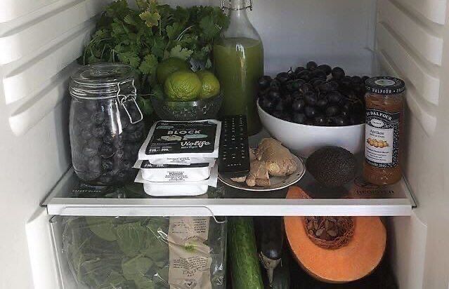 an open refrigerator filled with lots of food and condiments on top of it