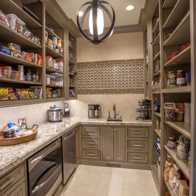 a kitchen filled with lots of counter top space next to a light hanging from the ceiling