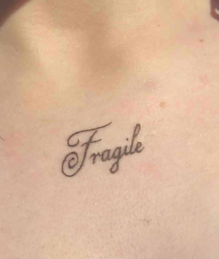 a woman's chest with the word fragile tattooed on her left side ribcage