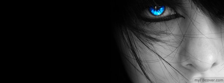 a woman's face with blue eyes in the dark