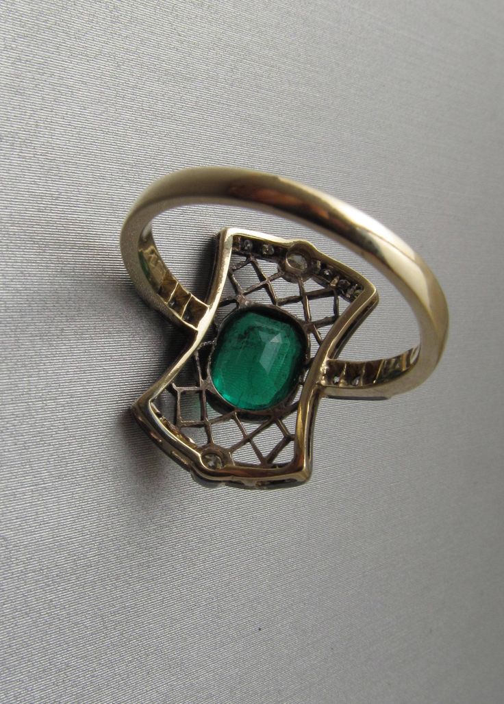 Art Deco emerald ring with diamonds, made of 14K gold and silver. With a Hungarian 14K hallmark that was used after 2016. The top part is made of silver. The head part of the ring is 0.796 inches (20 mm) long. Gemstone: one piece of emerald, 1.54 carat, its size is: 0.24 inches * 0.31 inches (6.1 mm * 7.8 mm) The emerald has inclusions which unfortunately affects the surface of the stone as well. I tried to make photos of that. Additional gemstone details: 20 single cut diamonds Carat weight: 0. Fine Jewelry Yellow Gold Emerald Ring With Intricate Design, Formal Emerald Ring With Intricate Design, Emerald Ring With Rose Cut Diamonds For Formal Occasions, Antique Yellow Gold Emerald Ring, Victorian Emerald Ring In Yellow Gold Stamped 14k, Antique Emerald Ring In Yellow Gold, Victorian Emerald Ring In 14k Yellow Gold, Antique Emerald Ring In Stamped 14k Yellow Gold, Antique 14k Stamped Emerald Ring