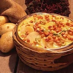 a basket filled with potatoes sitting next to some other food on top of a wooden table