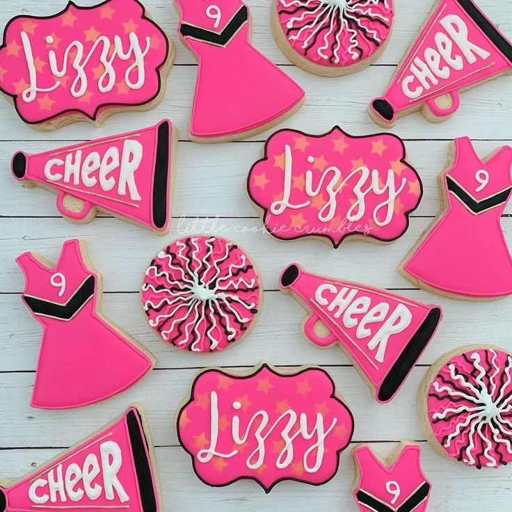 pink and black decorated cookies with the words cheer written on them, all in different shapes