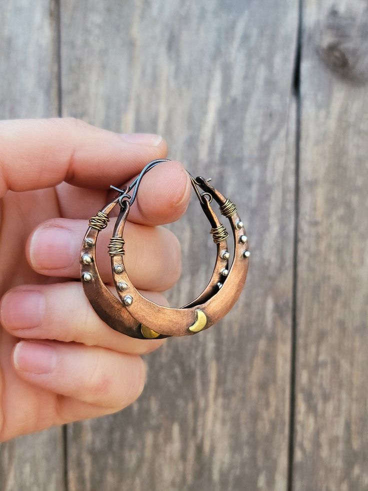 Lightly distressed copper hoop earrings with brass and silver accents                                                                                         These hoops are approximately 1 3/4 inches in length including the sterling silver wire Due to the nature of copper, brass and silver - the patina may change over time  Small imperfections may be present Your earrings will come packaged in biodegradable materials Bohemian Small Copper Hoop Earrings, Artisan Small Hoop Copper Jewelry, Small Hoop Hammered Copper Earrings, Hammered Copper Round Hoop Earrings, Artisan Copper Hoop Earrings, Pierced, Unique Hoop Earrings, Biodegradable Materials, Brass Hoop Earrings, Painted Earrings