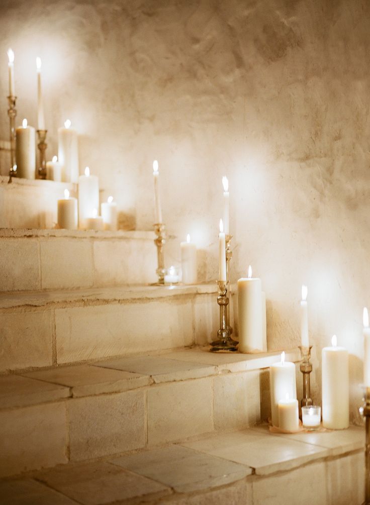 candles are lined up on the stairs in a room