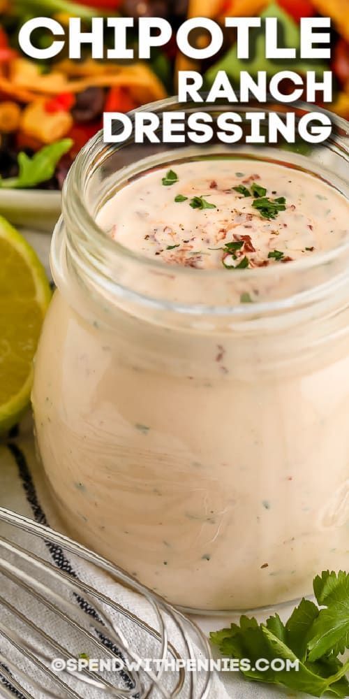 a jar filled with ranch dressing next to a salad