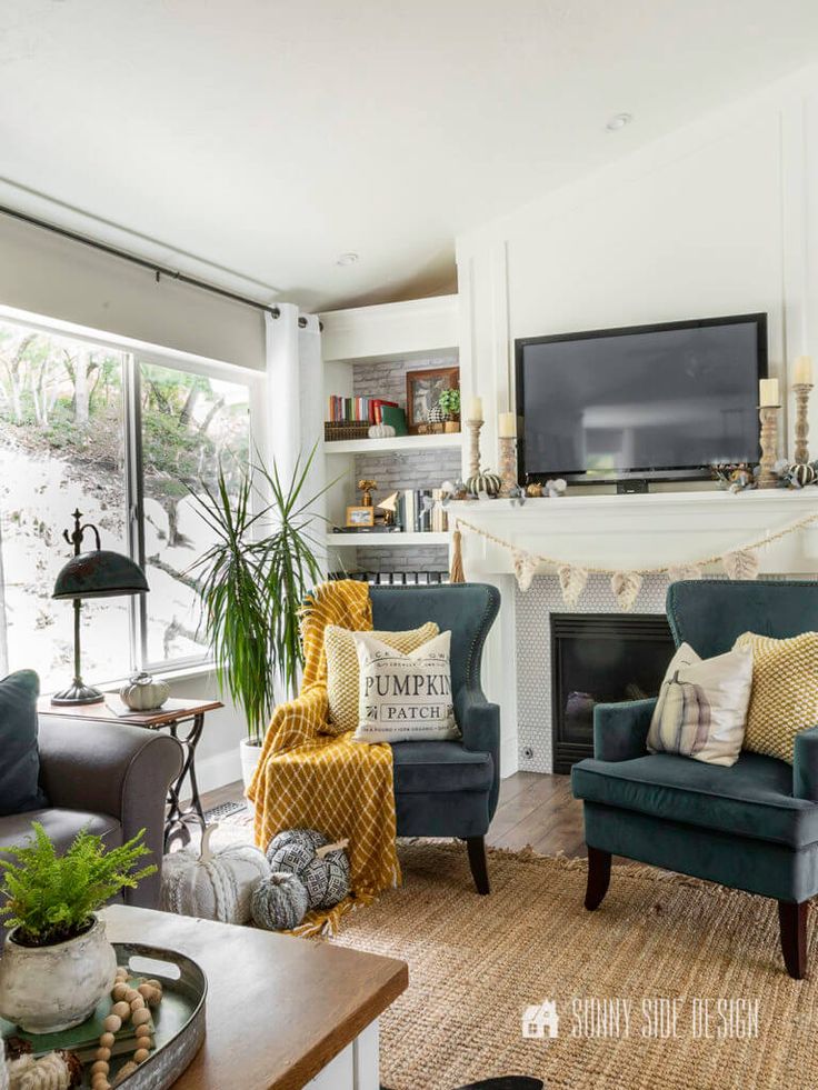 a living room filled with furniture and a flat screen tv mounted on the wall above a fire place