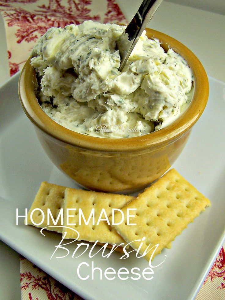 a bowl filled with cheese and crackers on top of a white plate