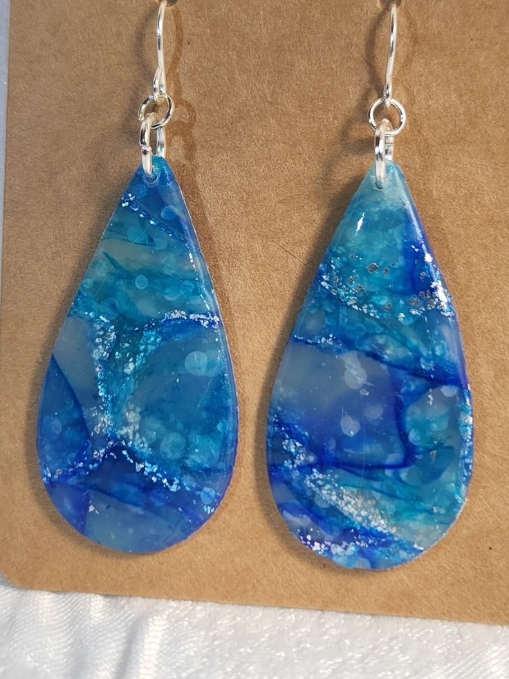 Large Blue Marbled teardrop dangle earrings. Made of polymer clay and resin with sterling silver hooks. Teardrop Clay Earrings, Handmade Resin Teardrop Earrings, Handmade Teardrop Resin Earrings, Teardrop Resin Jewelry, Resin Teardrop Earrings For Gifts, Unique Teardrop Resin Earrings, Blue Teardrop Pendant Earrings As Gift, Blue Teardrop Resin Jewelry, Blue Long Drop Teardrop Earrings