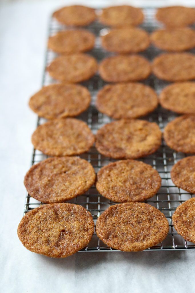 some cookies are cooling on a wire rack and ready to be baked in the oven