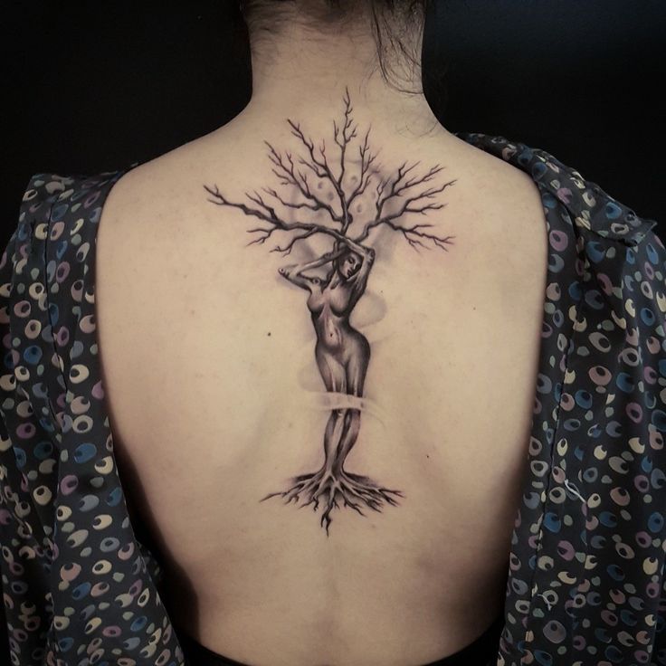 a woman with a tree tattoo on her back