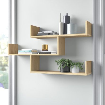 two white shelves with plants and books on them