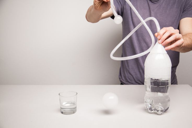 a man is holding an object in one hand and spraying it with a water bottle on the other