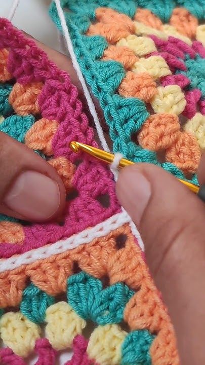 someone is crocheting together with yarn in their hands and they are working on something