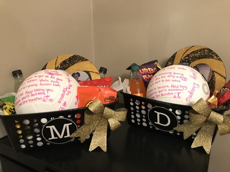 two black baskets filled with personalized items on top of a table next to each other