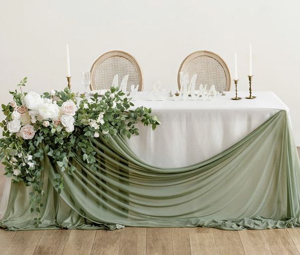 the table is covered with green cloth and flowers