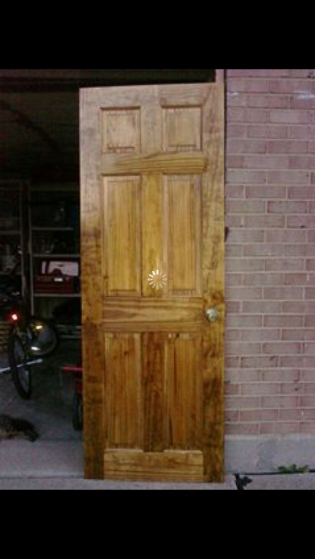 an open wooden door in front of a brick building with a motorcycle parked next to it