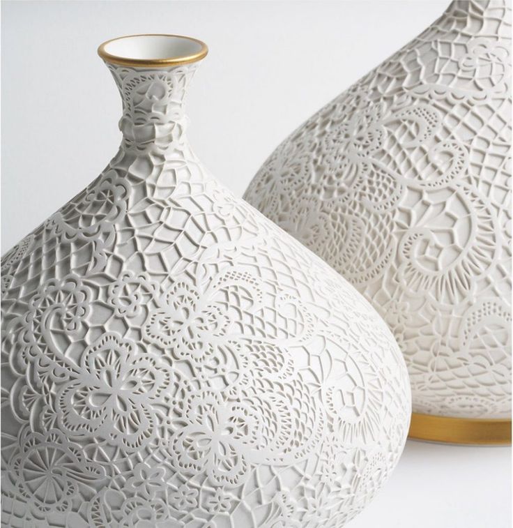 two white vases sitting next to each other