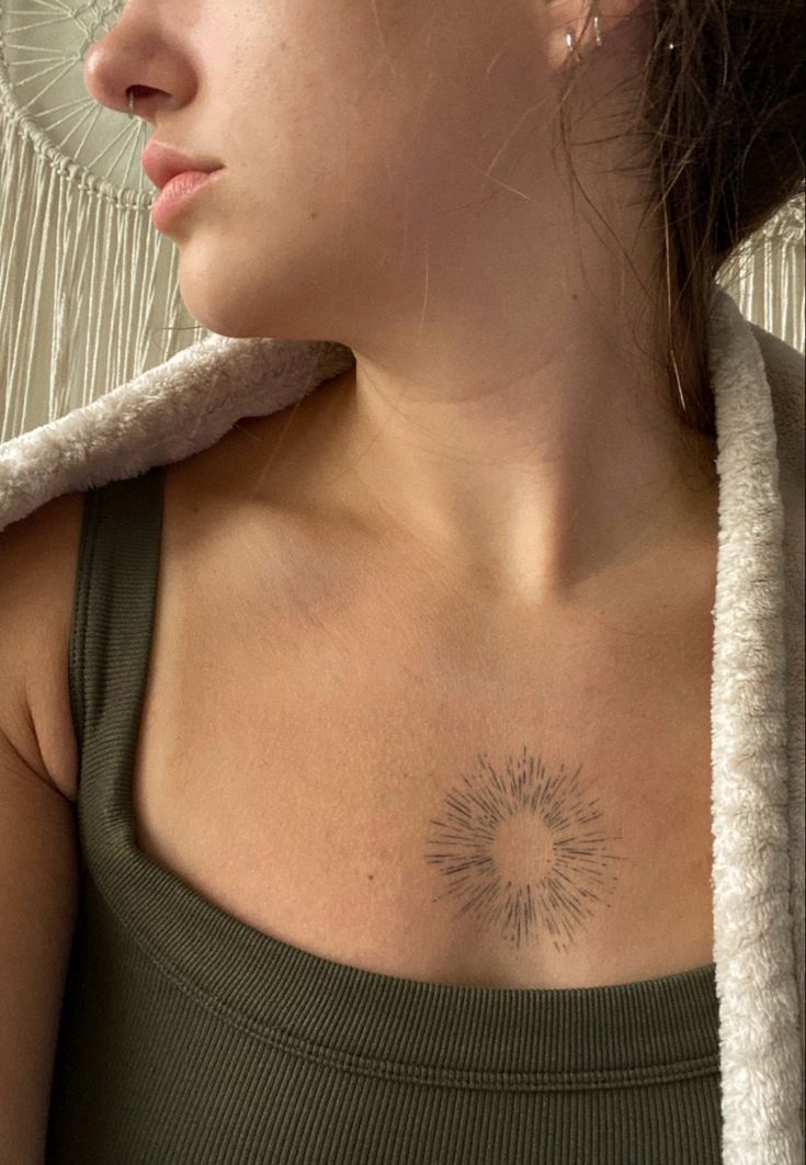 a woman with a sun tattoo on her chest