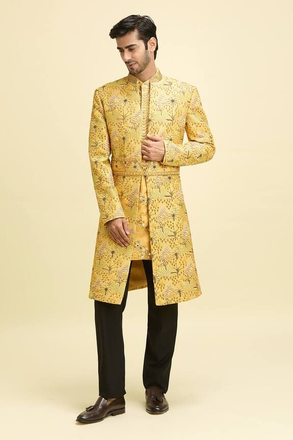 Yellow full sleeves longline bundi with all over Palm island embroidery using multi toned resham thread and cutdana highlights. Paired with a mirror embroidered short kurta and a matching embroidered belt. - Aza Fashions Silk Nehru Jacket With Chikankari Embroidery Long Sleeve, Fitted Long Sleeve Nehru Jacket With Chikankari Embroidery, Festive Bandhgala With Cutdana And Long Sleeves, Bollywood Style Silk Sherwani For Ceremonial Occasions, Fitted Sherwani With Intricate Embroidery And Long Sleeves, Fitted Long Bandhgala With Chikankari Embroidery, Gold Silk Bandhgala For Festivals, Festive Long Sleeve Bandhgala With Cutdana, Yellow Long Sleeve Traditional Wear With Intricate Embroidery