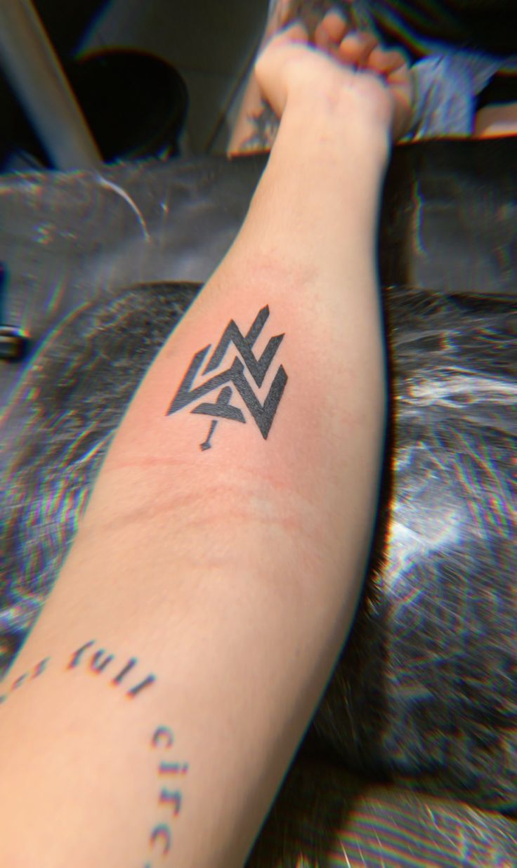 a person's arm with a tattoo on it and an arrow in the middle