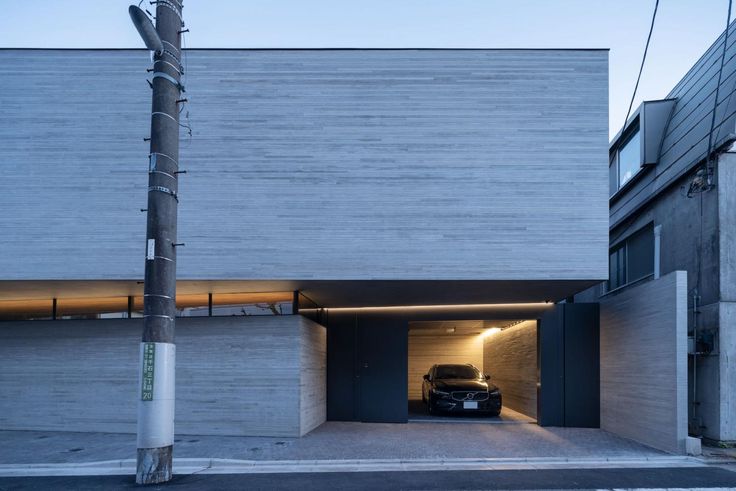 the car is parked in the garage on the side of the building with its door open