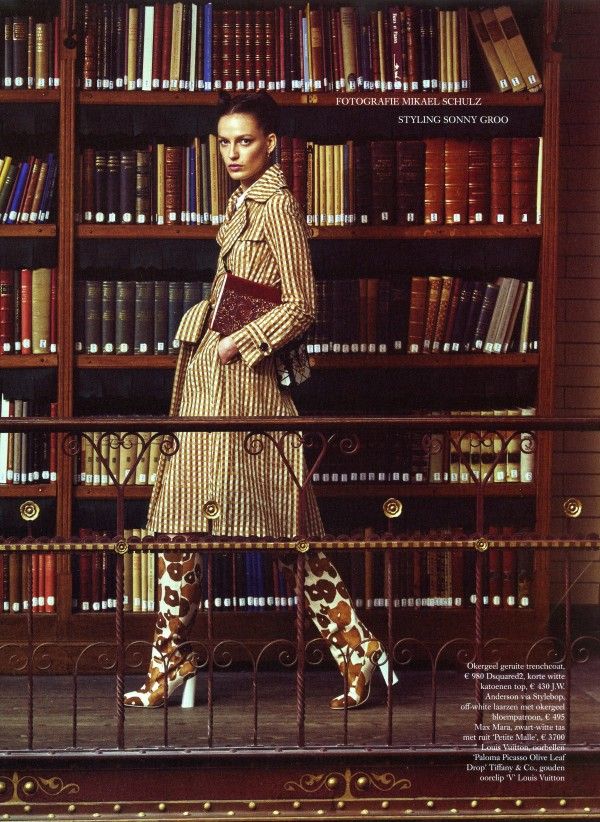 a woman standing in front of a bookshelf with lots of books on it