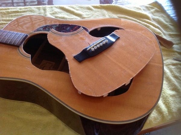 an acoustic guitar sitting on top of a bed