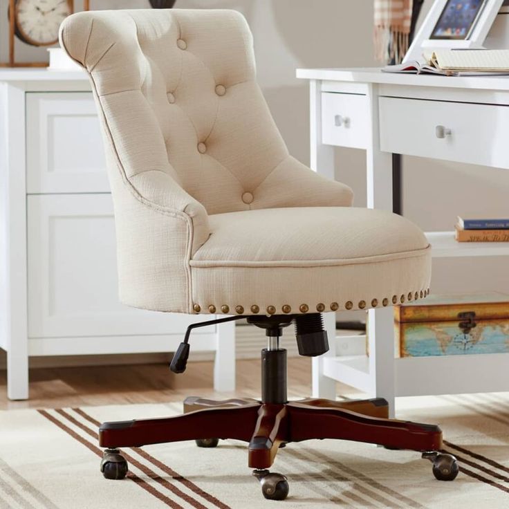 an office chair sitting on top of a wooden floor in front of a white desk