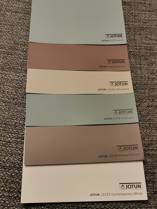 four different shades of paint sitting on top of a carpeted floor next to each other