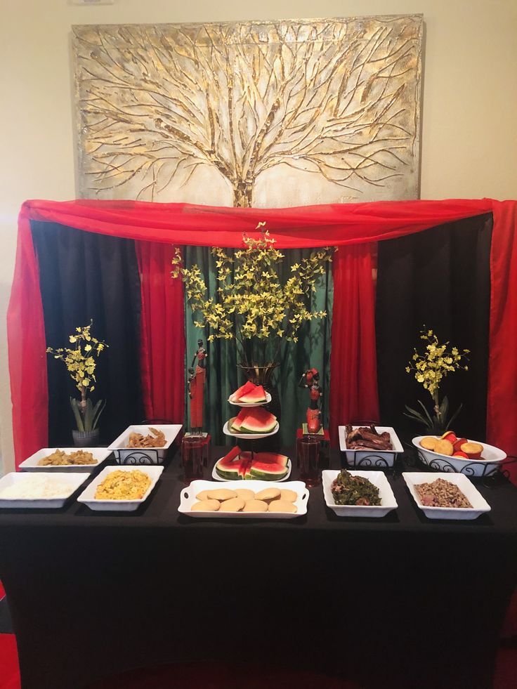 the table is set up with many different foods on it and flowers in vases