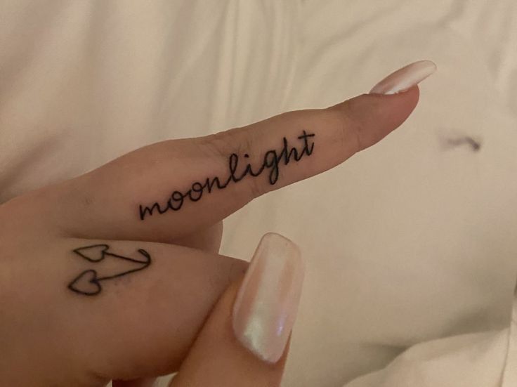 a person's hand with a tattoo that reads moonlight