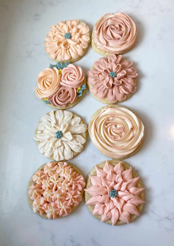 six decorated cupcakes sitting on top of a white counter