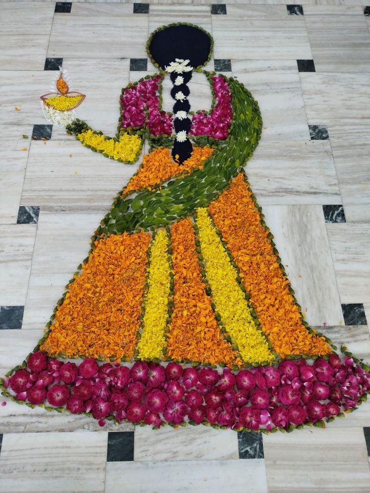 a woman in an orange and yellow dress is made out of flowers on the floor