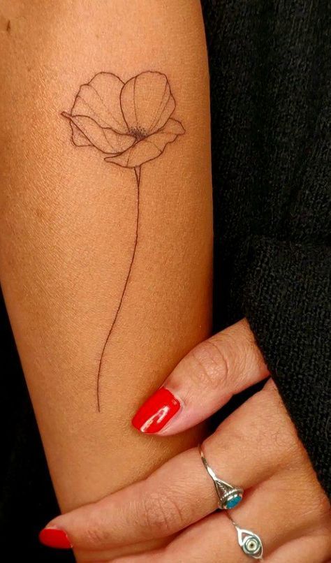 a woman's arm with a flower tattoo on the left side of her arm