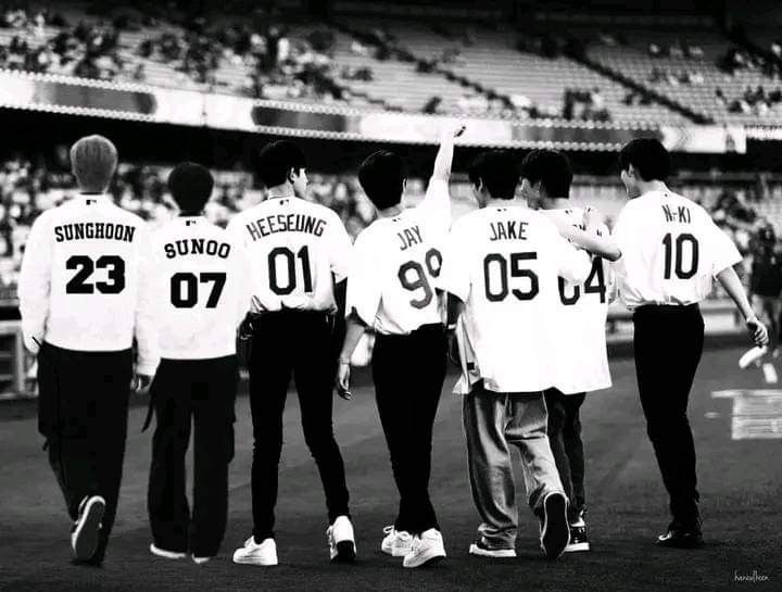 some baseball players are standing on the field and one has his hand up in the air