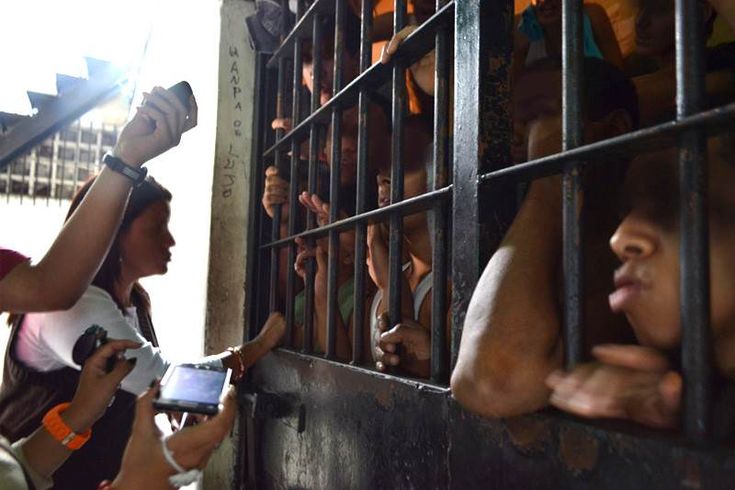 several people in jail looking at cell phones